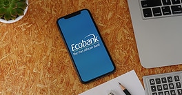 Ecobank Phone App with Stationery and Macbook. Ecobank is a pan-African banking conglomerate