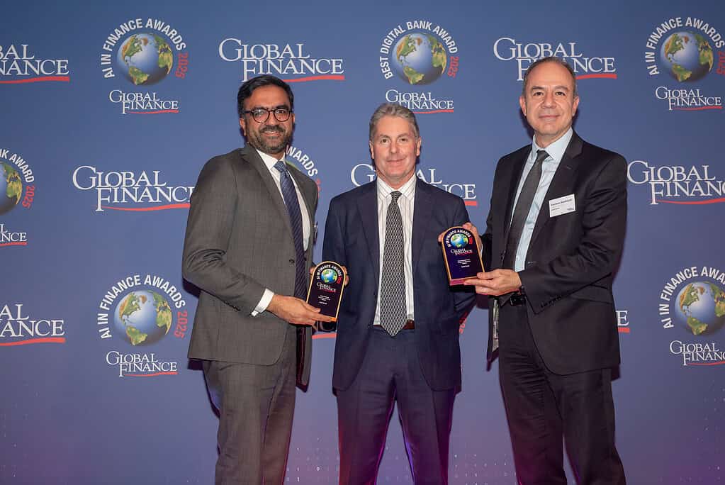 Award ceremony at Global Finance Magazine Awards 2023, featuring three professionals holding trophies against a branded backdrop.