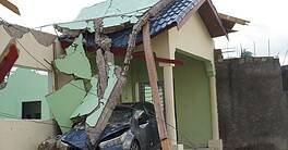 A car lies crushed under the debris of a collapsed building, showcasing the destructive force of Hurricane Melissa in Jamaica, Friday, 31 October 2025