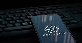 Grayscale investing logo on smartphone screen laying on computer keyboard