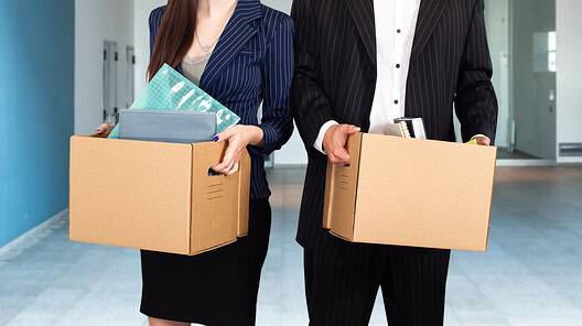 Unemployed managers with boxes in hands. Mass layoff of office staff concept. Fired man and woman in empty room. Problem of unemployment in society. Reduction of white collar workers
