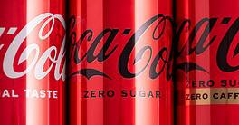 Set of iron cans of drink Coca Cola: classic, zero sugar, zero sugar zero caffeine, cherry flavor on red background. Top view