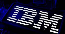 IBM Company Logo Illuminated On Smartphone Screen With Blue CPU Computer LED Motherboard And Circuit Wafer Chip Technology Background