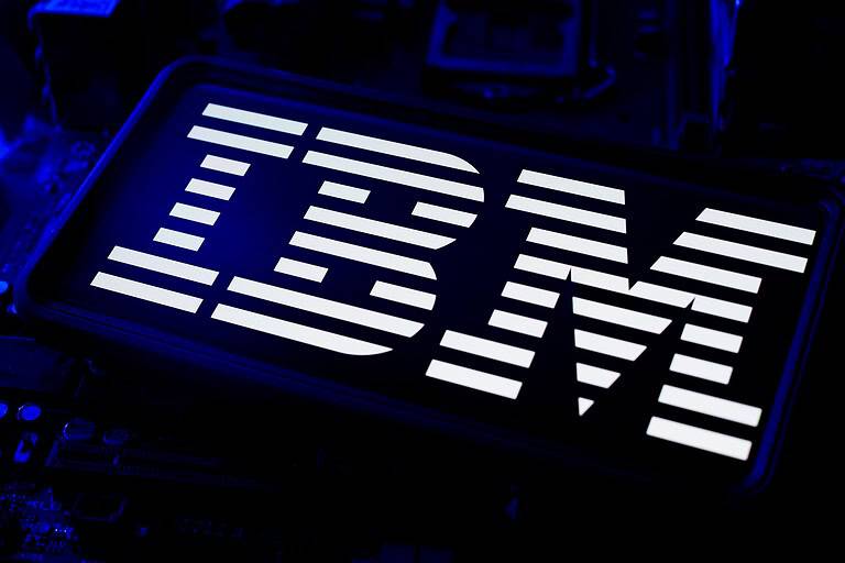 IBM Company Logo Illuminated On Smartphone Screen With Blue CPU Computer LED Motherboard And Circuit Wafer Chip Technology Background