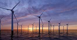 Windmill park. Offshore wind turbines farm on the ocean. Sustainable energy production. Green Energy, clean power, clean energy concept.