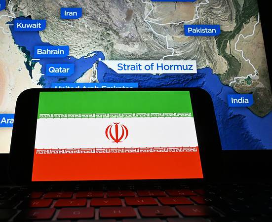 The Iranian flag is visible on the screen. After U.S. attacks, Iran decided to close the Strait of Hormuz.