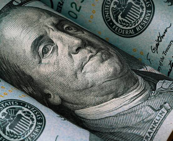 Closeup of Benjamin Franklin face on USD dollar banknote for dollar is the main of currency exchange in the world.