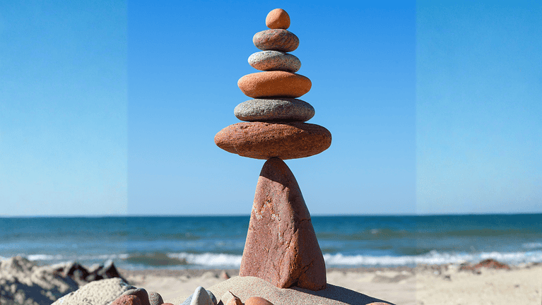 Rock zen pyramid balanced on a cliff edge on the beach. Concept of Life balance, harmony and meditation