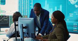 A diverse team of fintech professionals analyzing financial charts and infographics on a large screen in a modern corporate boardroom