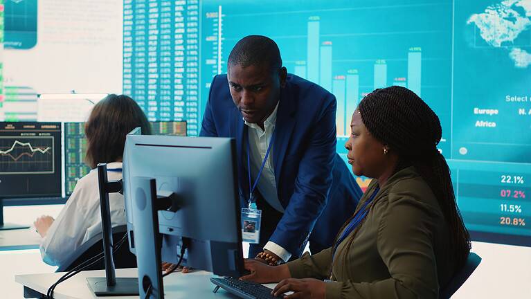 A diverse team of fintech professionals analyzing financial charts and infographics on a large screen in a modern corporate boardroom
