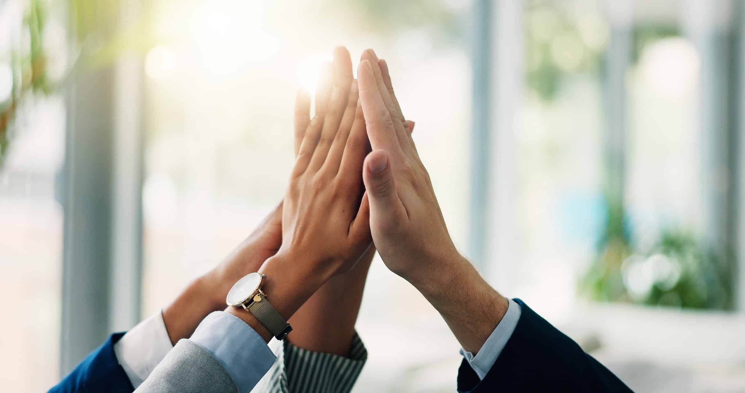 Business people's hands high-fiving