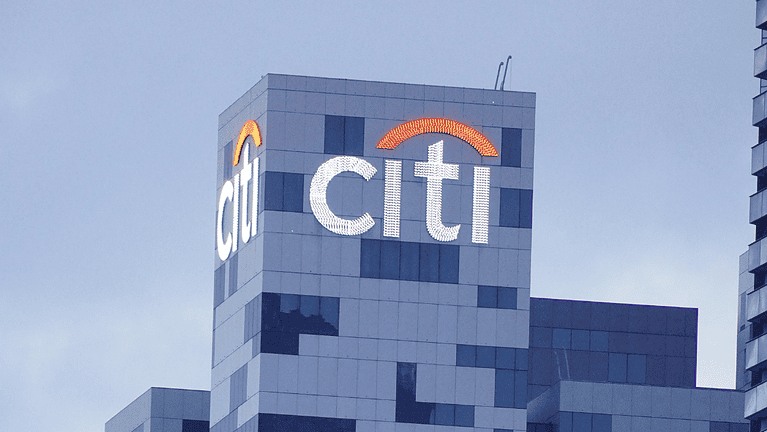 Citi logo on a modern office skyscraper in an urban setting.
