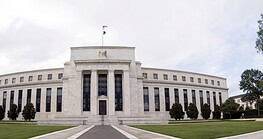 Federal Reserve building with a flag on top and surrounding trees.