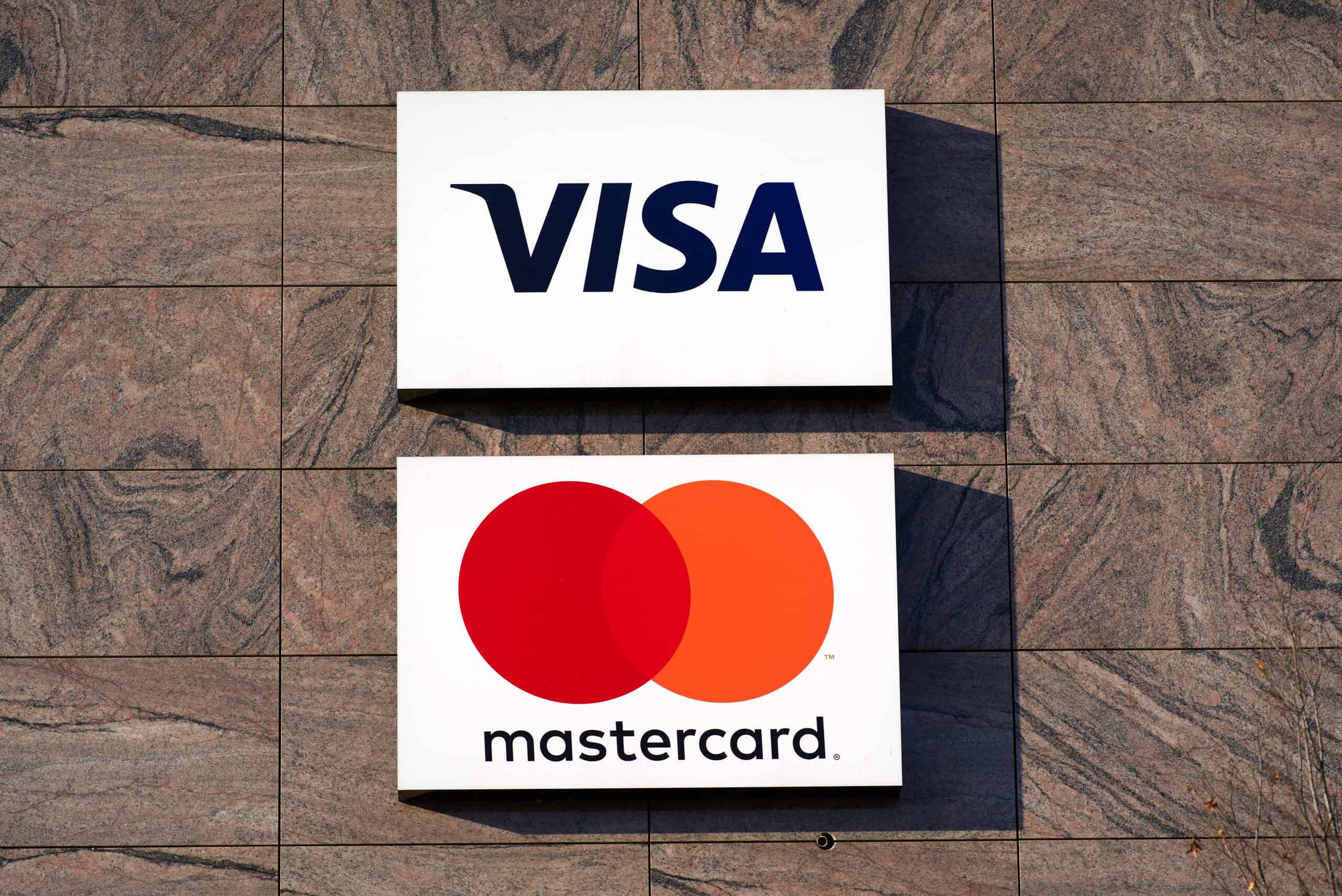 Logos of Visa and Mastercard credit card companies at stone facade of office building at Zürich Glattbrugg on a sunny winter day. Photo taken January 13th, 2022, Zurich, Switzerland.