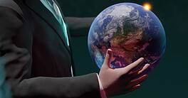 Business professional holding Earth with sunrise, global finance concept.