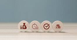 Set of four wooden tokens with finance and investment icons.