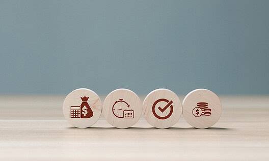 Set of four wooden tokens with finance and investment icons.