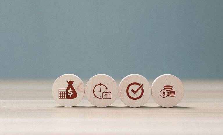 Set of four wooden tokens with finance and investment icons.