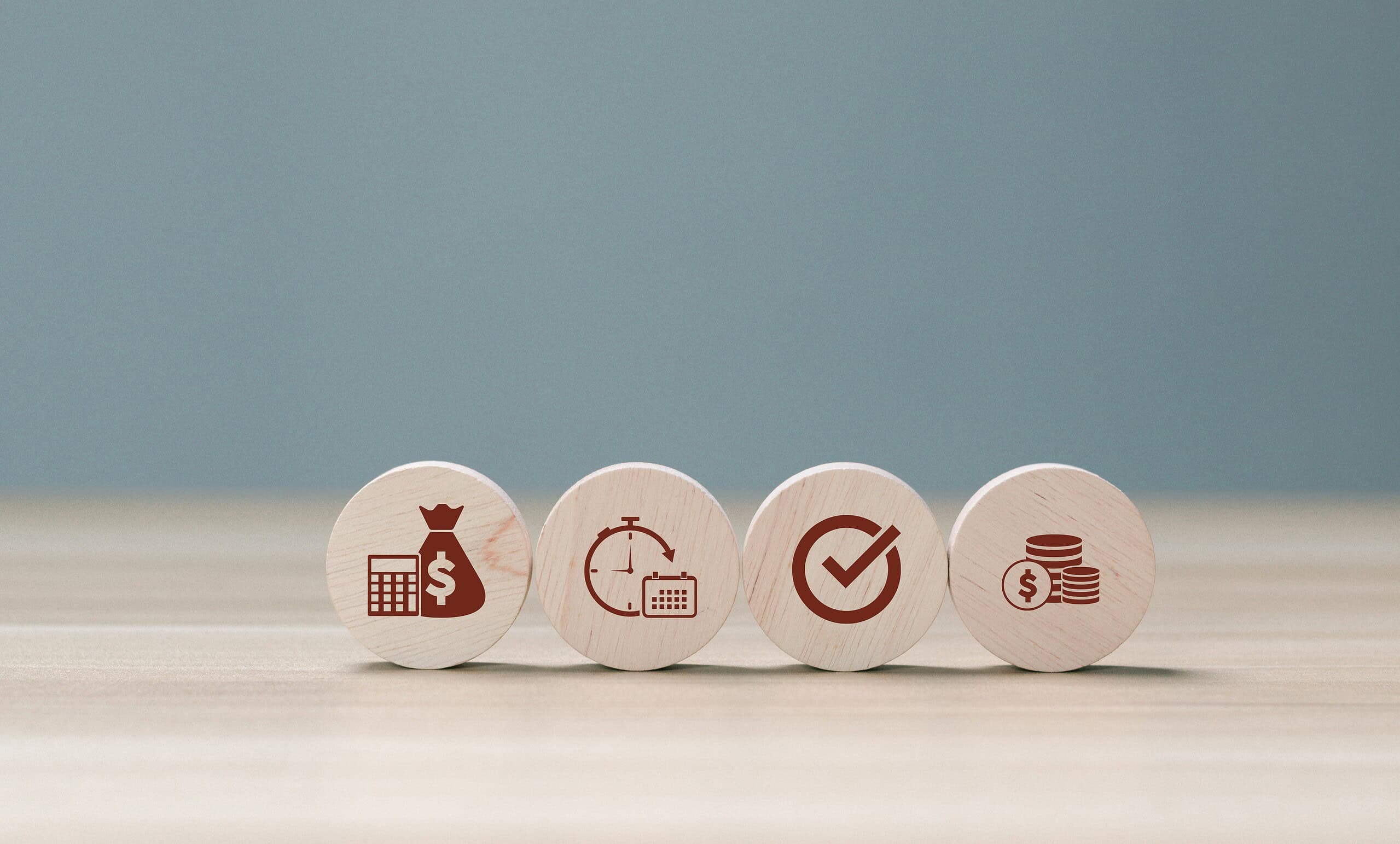 Set of four wooden tokens with finance and investment icons.