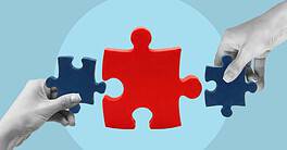 Two hands holding puzzle pieces fitting together for finance.