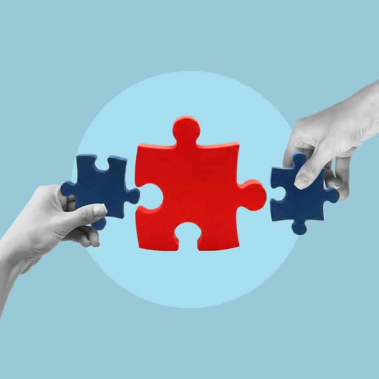 Two hands holding puzzle pieces fitting together for finance.