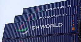Global Logistics and Supply Chain Concept with Stacked dark blue containers for marine shipping of DP World logistics, with its logs DP WORLD clearly painted in white on the dark blue coating of the containers against blue sky in a container yard