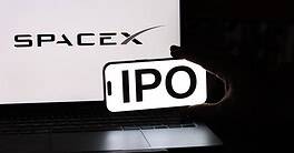 SpaceX IPO announcement displayed on a smartphone in front of a laptop.