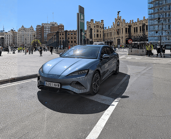 Blue BYD electric vehicle parked in urban city square with historic buildings.