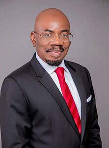 Prominent Nigerian banking executive in formal suit and glasses.