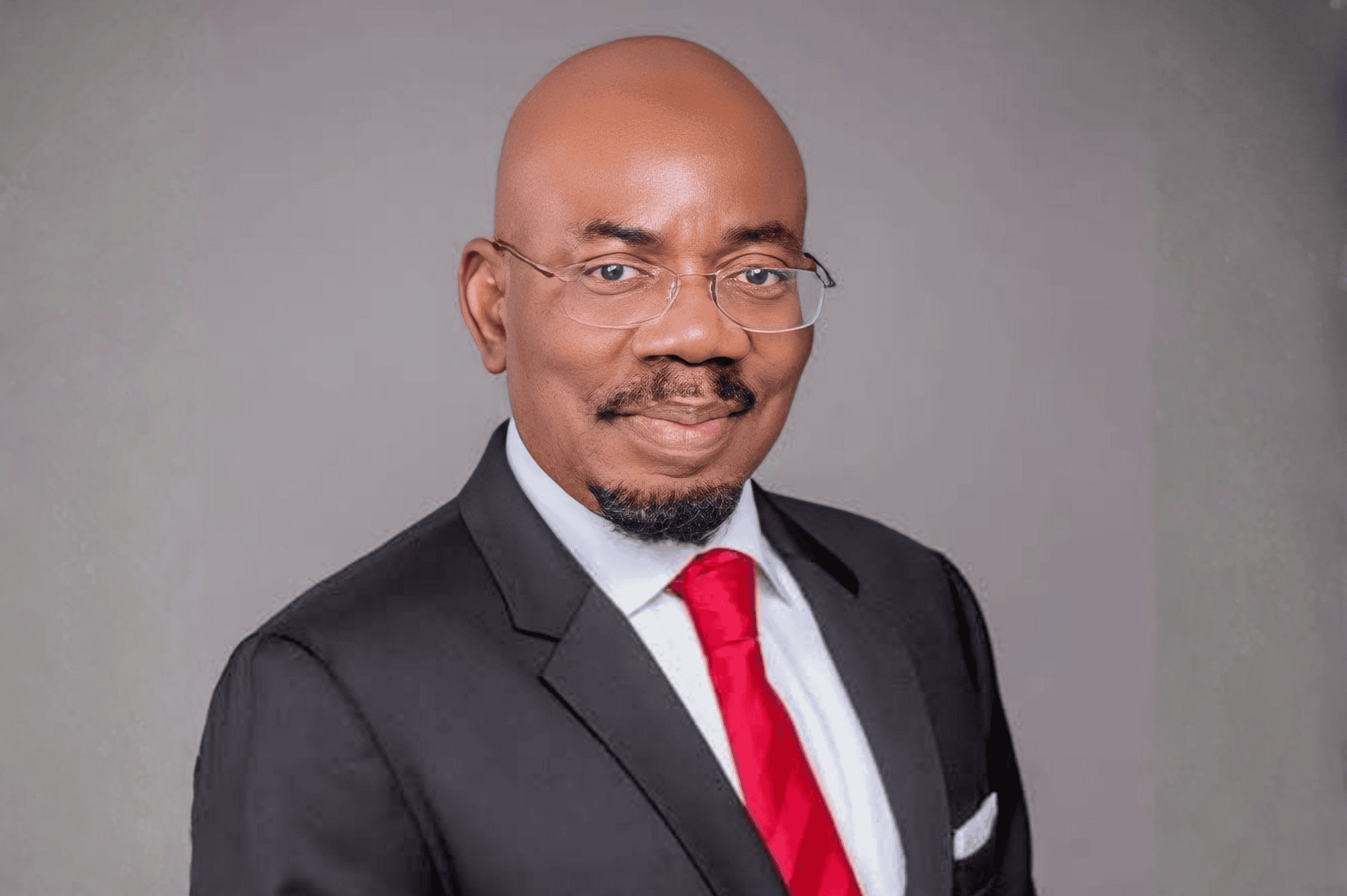 Jim Ovia in formal suit and glasses.