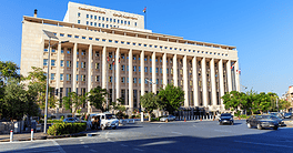 Central Bank building in Syria with flags and trees.