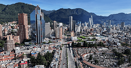 Panoramic view of Bogotá city with skyscrapers and mountains in the background.