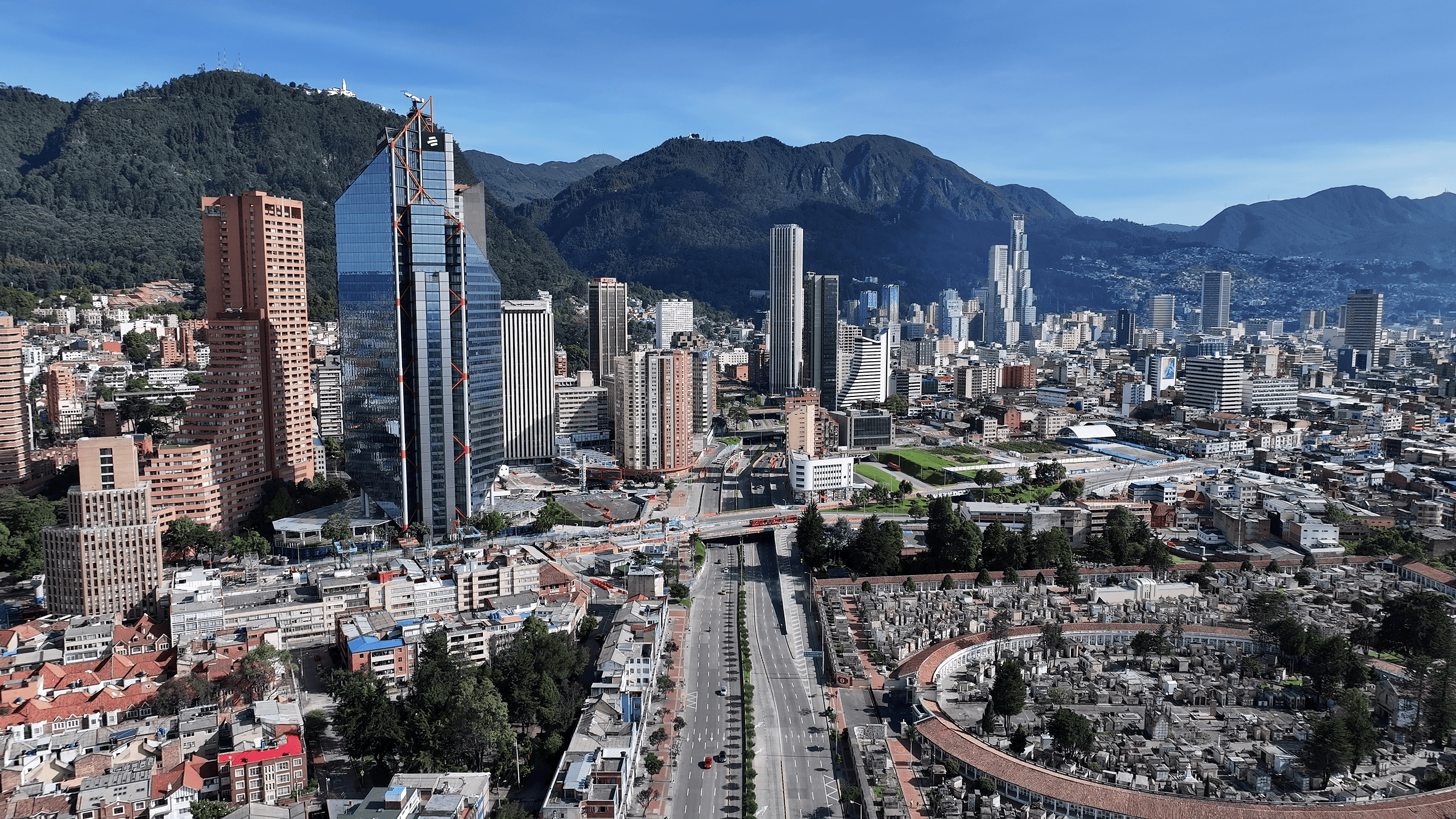 Panoramic view of Bogotá city with skyscrapers and mountains in the background.