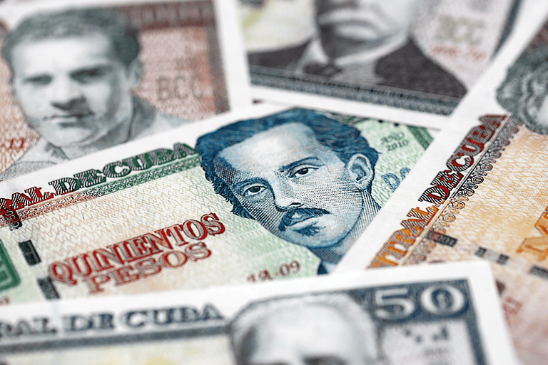 Cuban peso money bills pile on table. Cuba banknotes of CUP currency close up. Concept of business, economy and banking in Cuba