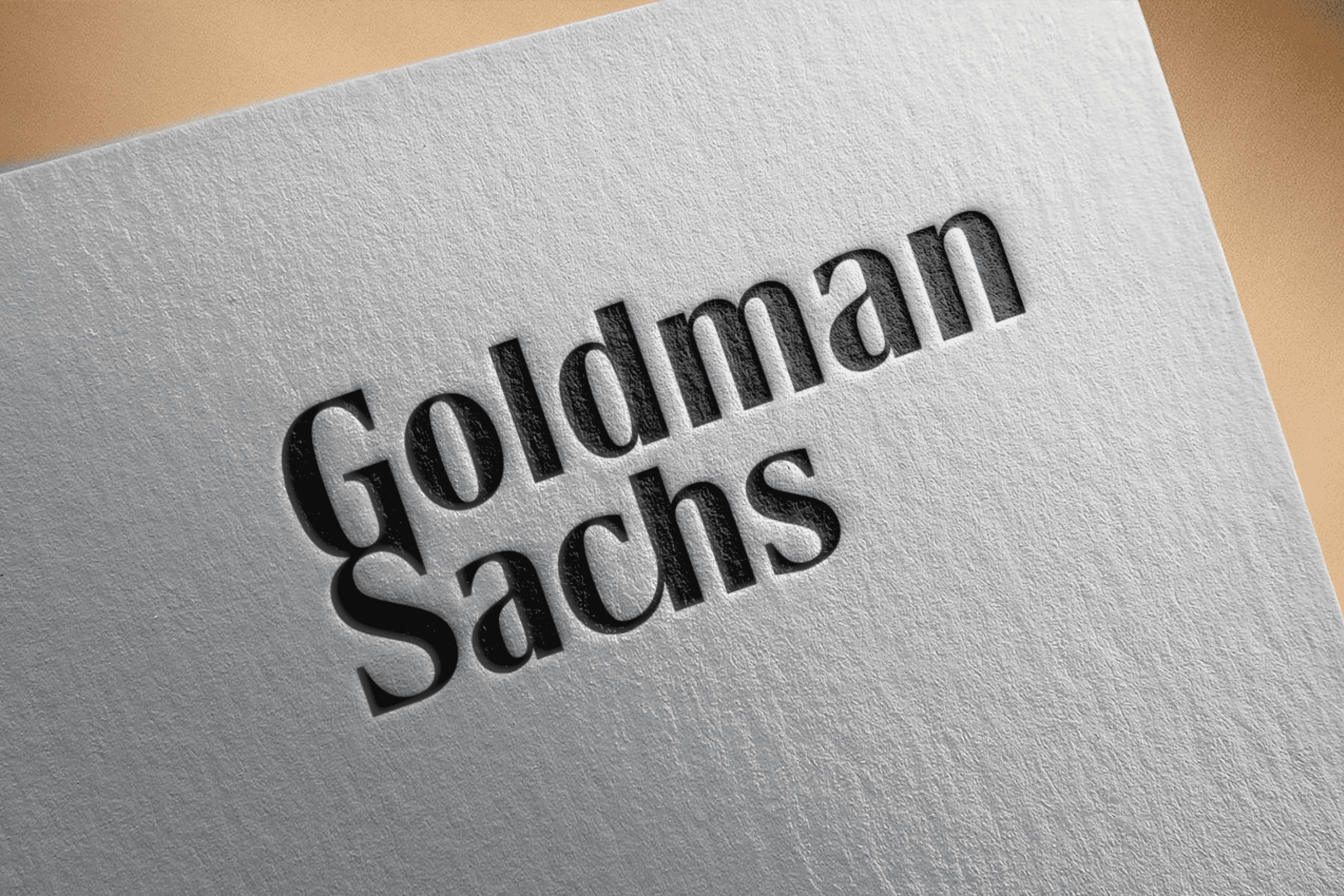 Minimal branding visual featuring Goldman Sachs logo printed on an angled white paper, symbolizing Goldman Sachs stock in a financial Stock market, investment