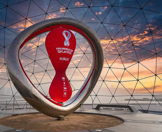 Qatar 2022 FIFA World Cup trophy inside a geodesic dome at sunset.