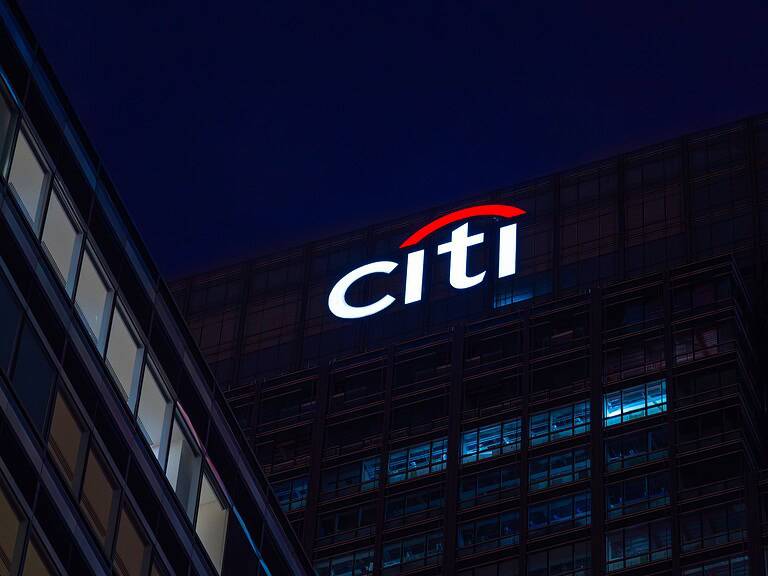 Citi logo illuminated on office building at night.