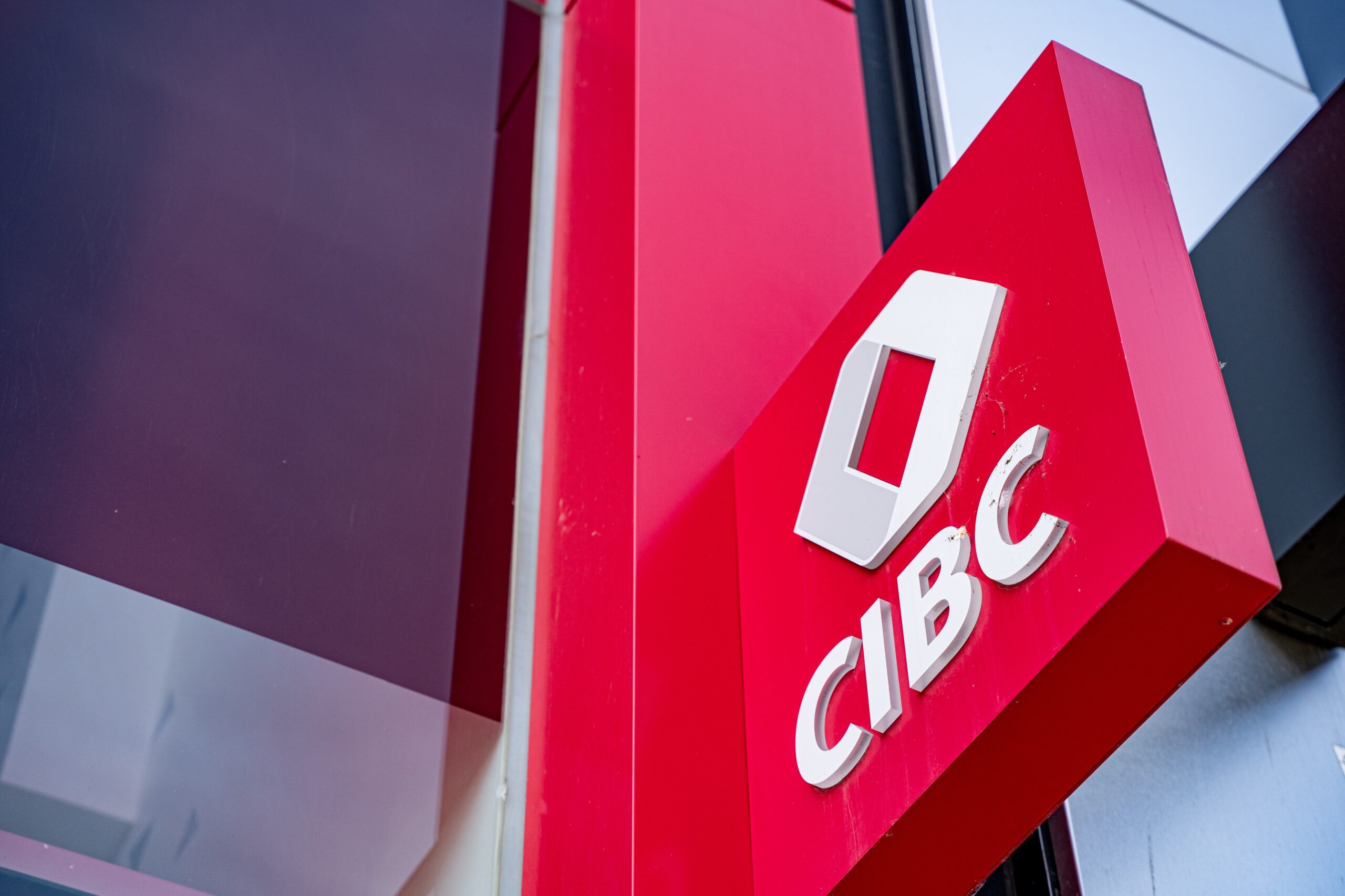 CIBC bank logo on building exterior in urban setting.