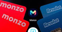 Revolut and Monzo fintech cards with logos on black background.