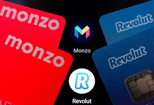 Revolut and Monzo fintech cards with logos on black background.