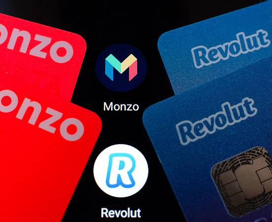 Revolut and Monzo fintech cards with logos on black background.