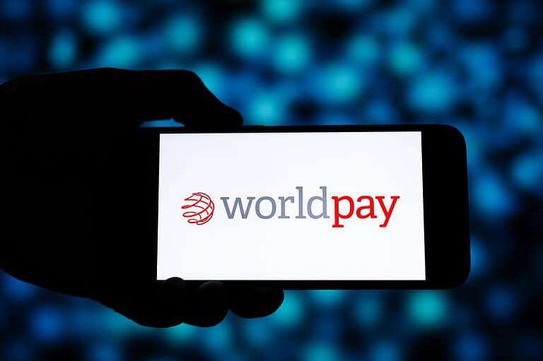 Worldpay logo displayed on a smartphone screen in a dark setting.