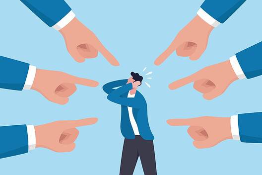 Person overwhelmed by multiple pointing fingers in workplace.