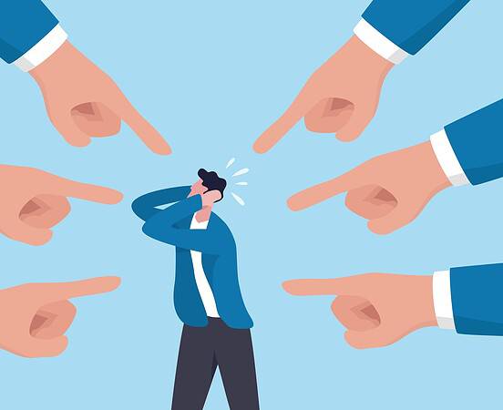 Person overwhelmed by multiple pointing fingers in workplace.