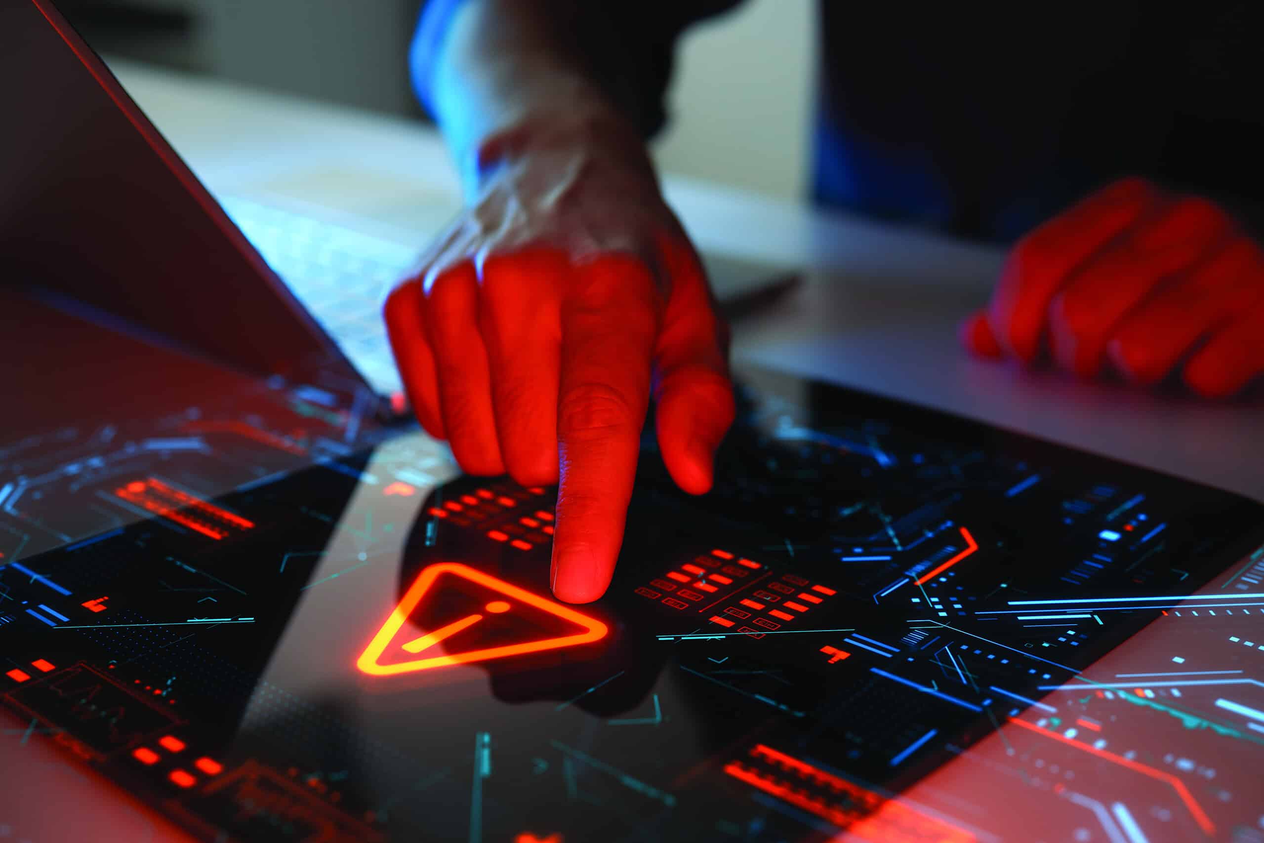 Man interacting with a holographic touchscreen interface in red color. Concept of cyber attack, malware, data breach, system hacking, virus, spyware, compromised information and urgent attention.