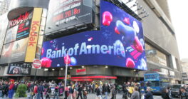 NEW YORK CITY - APRIL 19: Pedestrians walk past a giant sign advertising a Bank of America branch office in New York City.