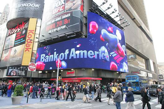NEW YORK CITY - APRIL 19: Pedestrians walk past a giant sign advertising a Bank of America branch office in New York City.
