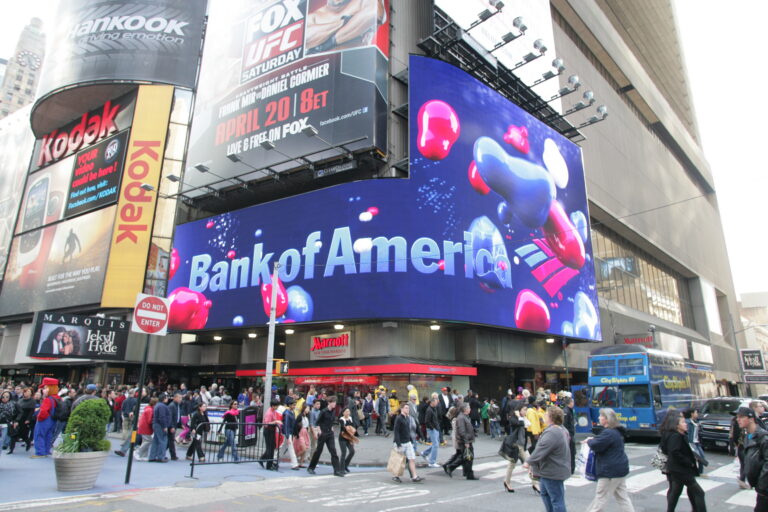 NEW YORK CITY - APRIL 19: Pedestrians walk past a giant sign advertising a Bank of America branch office in New York City.