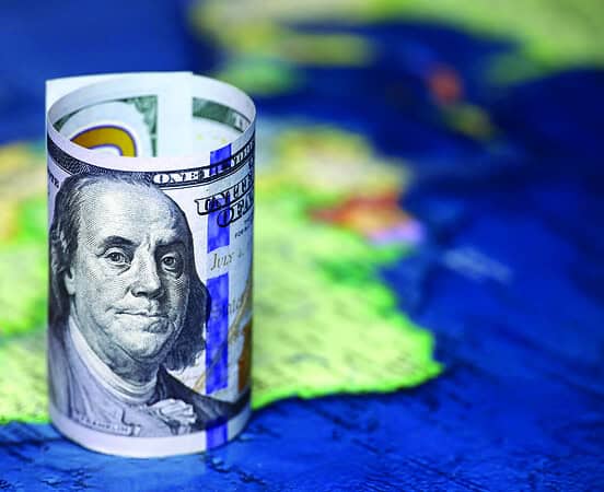 Rolled up one hundred dollar bill on top of a South America map
