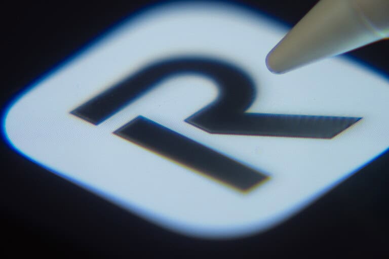 Close-up of the Revolut app icon on a smartphone screen with a stylus.